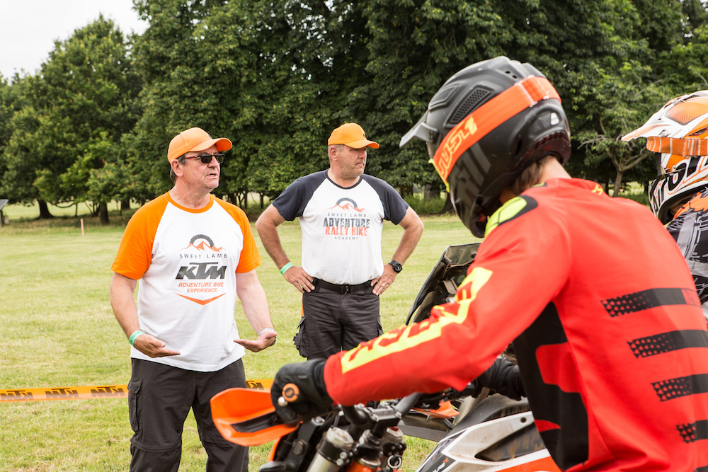 Instructors from the KTM off-road school teach motorcyclists in a field