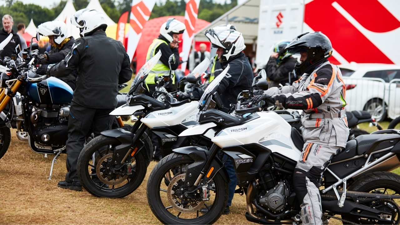 A group of motorcyclists taking Triumph Tiger motorbikes for a test ride